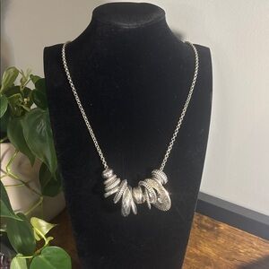 Elegant Silvertone necklace with variety of sizes and shapes.